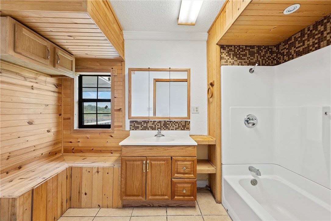821 Old Country Road Moody, TX 76557 - Photo 8 of 21 a bathroom with a granite countertop sink and a bathtub
