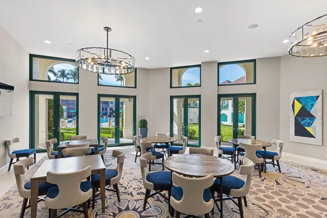 a view of a dining room with furniture a chandelier and a window