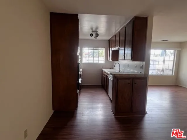 a kitchen with granite countertop white cabinets and wooden floor