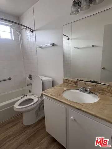 a bathroom with a granite countertop sink a toilet and a mirror