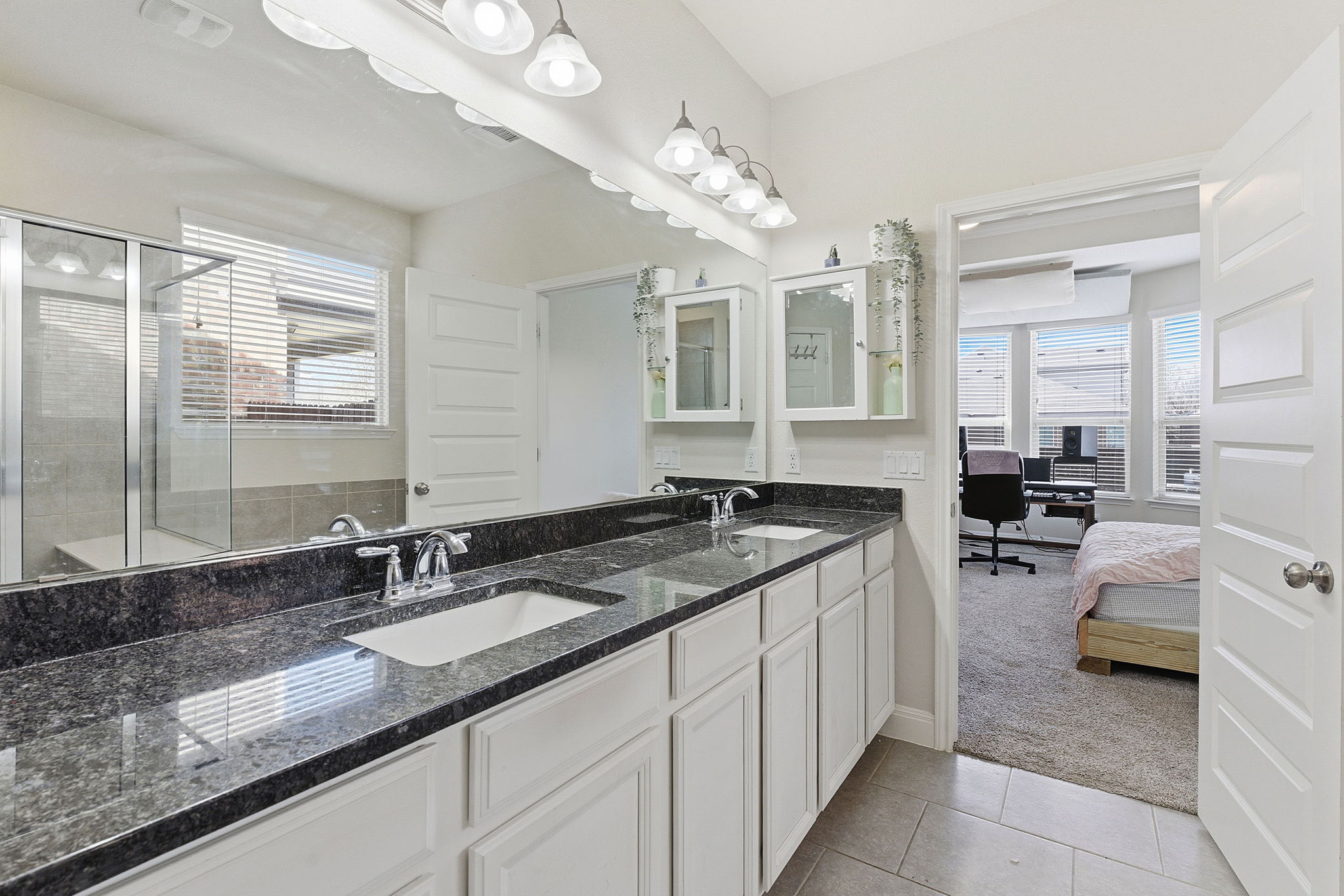 117 Methodius Drive Hutto, TX 78634 - Photo 17 of 40 Ensuite bathroom with double vanity, light colored carpet, light tile patterned floors, a stall shower, and plenty of natural light