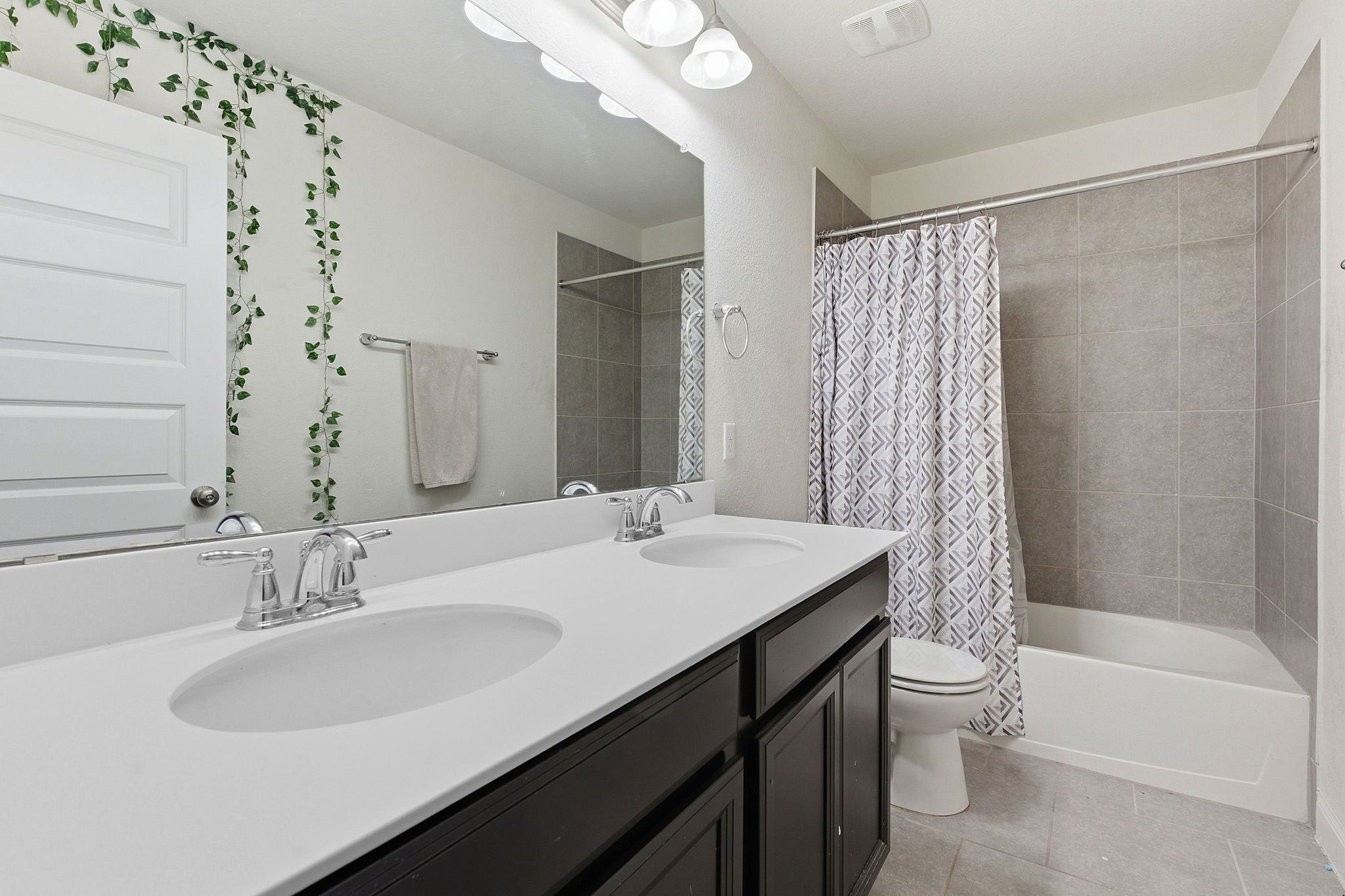 117 Methodius Drive Hutto, TX 78634 - Photo 23 of 40 Bathroom with double vanity, shower / bath combo with shower curtain, and light tile patterned floors