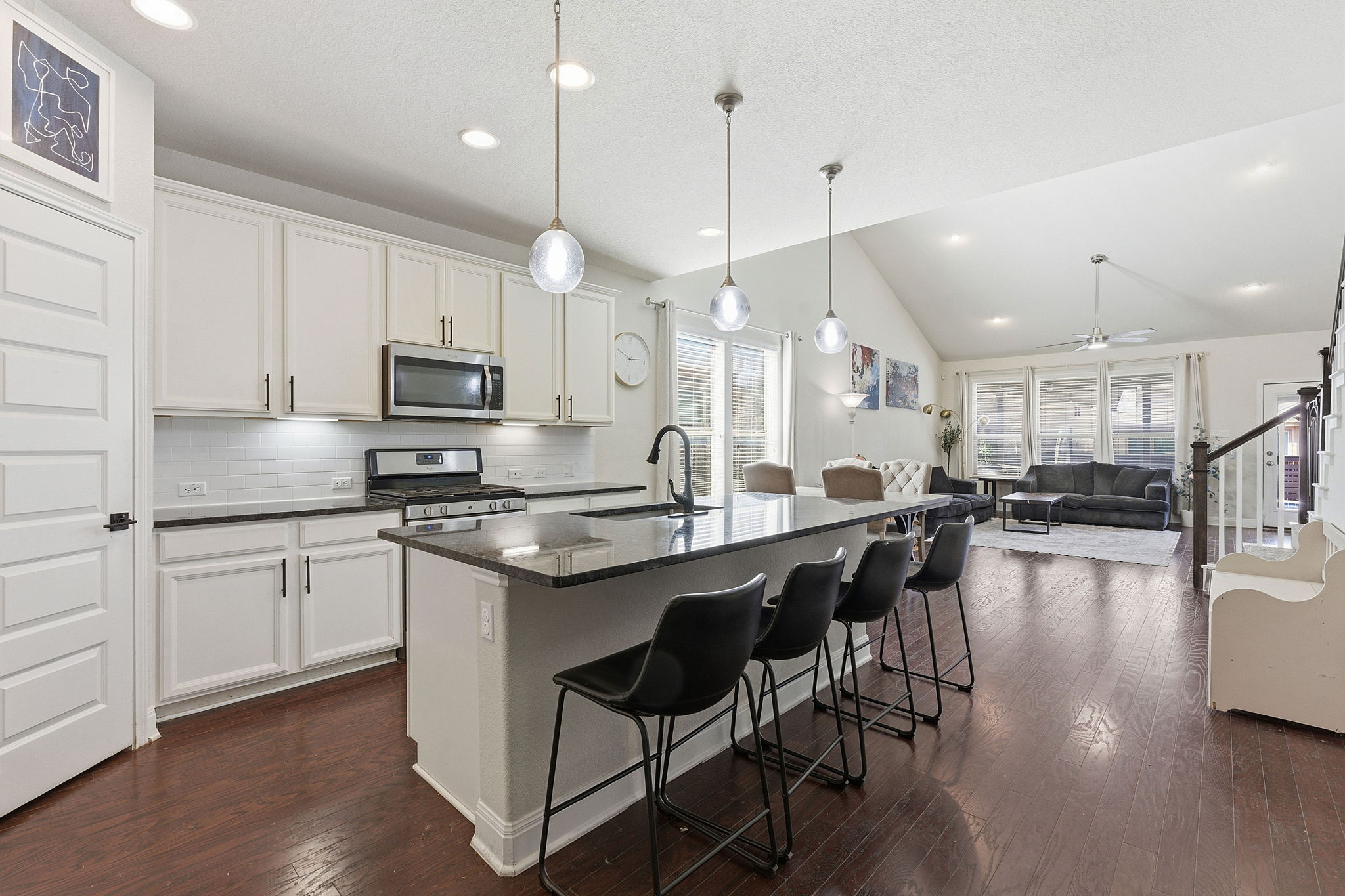 117 Methodius Drive Hutto, TX 78634 - Photo 7 of 40 Kitchen featuring an island with sink, a breakfast bar, stainless steel appliances, dark wood-style floors, and pendant lighting
