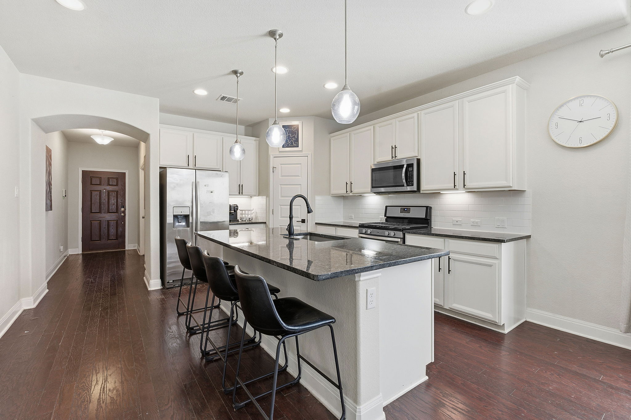 117 Methodius Drive Hutto, TX 78634 - Photo 8 of 40 Kitchen featuring stainless steel appliances, an island with sink, arched walkways, a kitchen bar, and white cabinetry