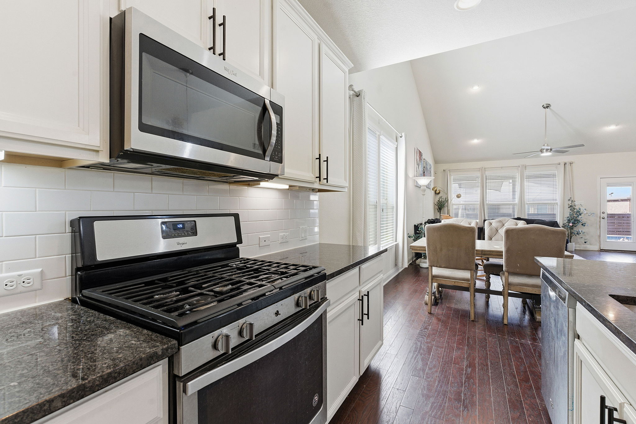 117 Methodius Drive Hutto, TX 78634 - Photo 10 of 40 Kitchen featuring stainless steel appliances, white cabinets, dark stone counters, a ceiling fan, and lofted ceiling