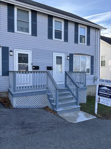 a view of a house with wooden deck and furniture