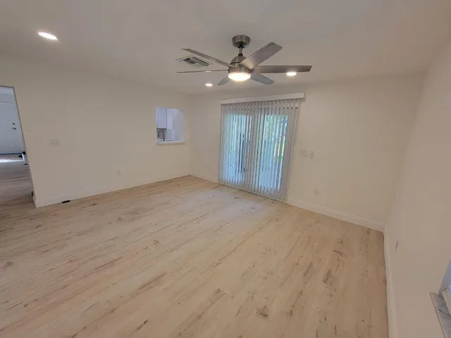 en empty room with wooden floor and ceiling fan