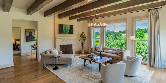 a living room with furniture a fireplace and a floor to ceiling window