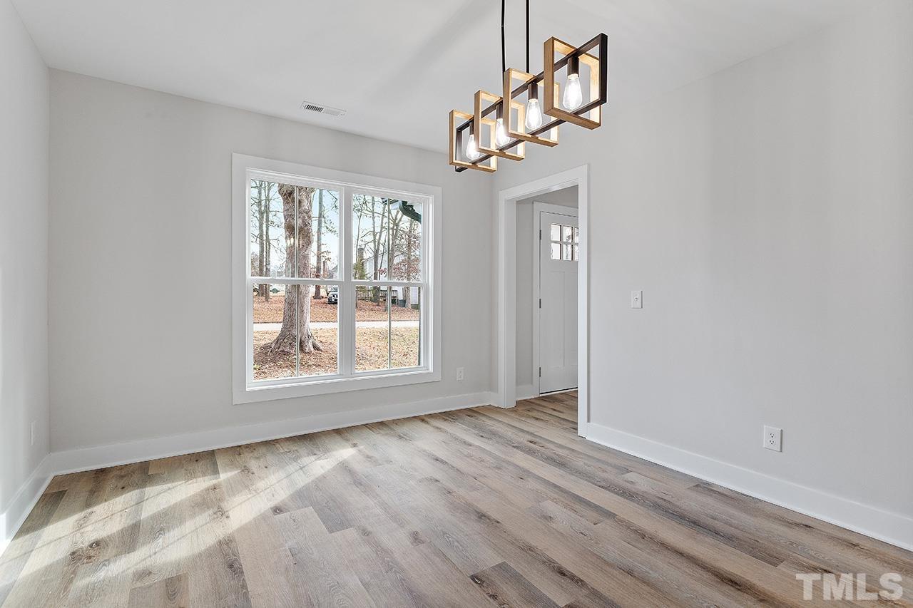8205 Rocky Court Raleigh, NC 27616 - Photo 15 of 28 a view of an empty room with wooden floor and a window