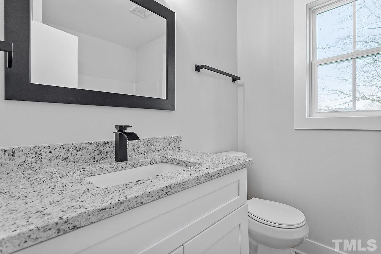 8205 Rocky Court Raleigh, NC 27616 - Photo 23 of 28 a bathroom with a granite countertop sink toilet and mirror