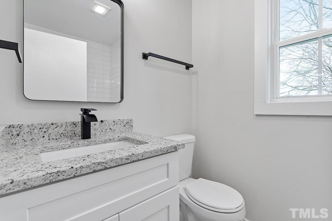 8205 Rocky Court Raleigh, NC 27616 - Photo 27 of 28 a bathroom with a granite countertop sink toilet and mirror