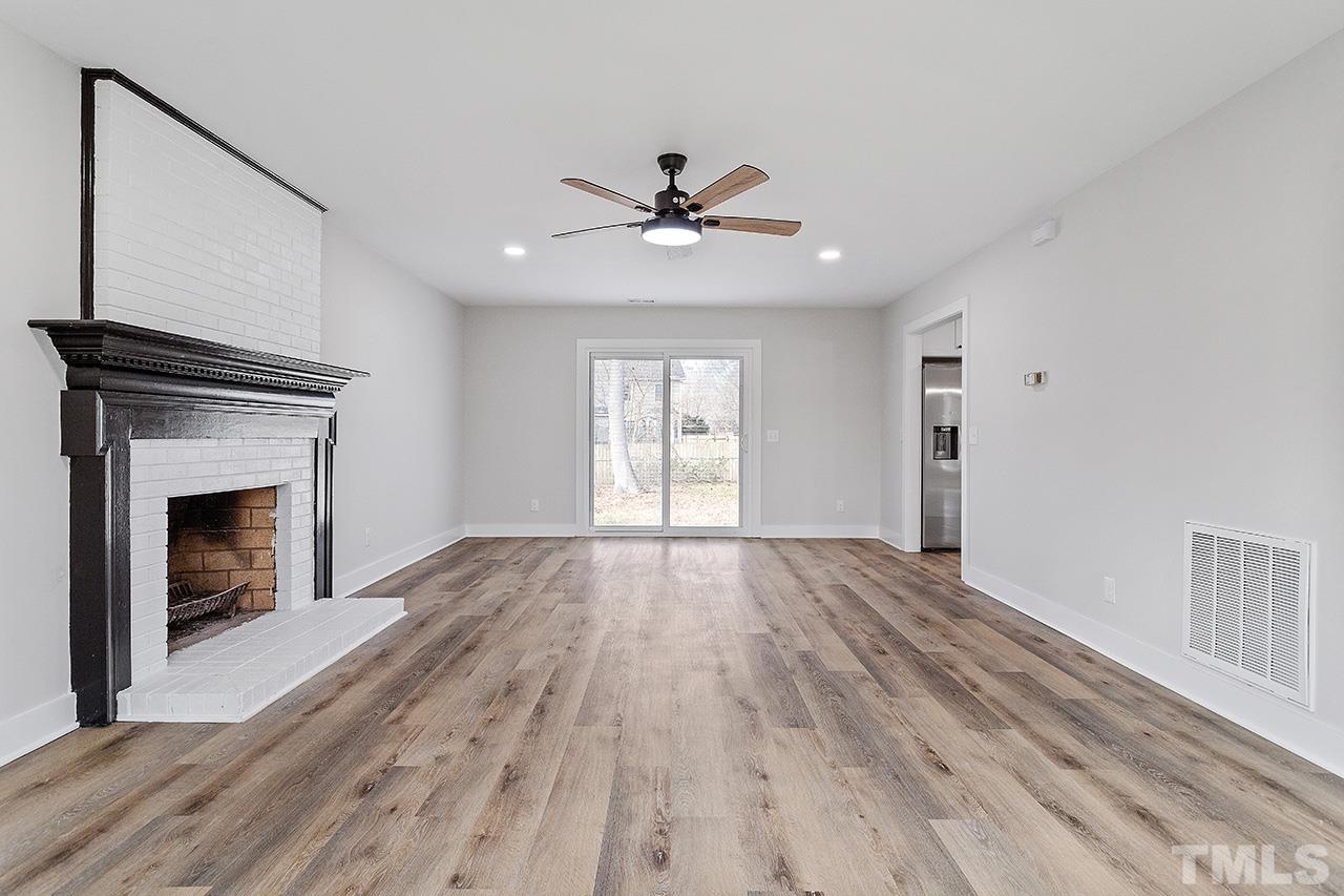 8205 Rocky Court Raleigh, NC 27616 - Photo 6 of 28 a view of empty room with wooden floor and fan
