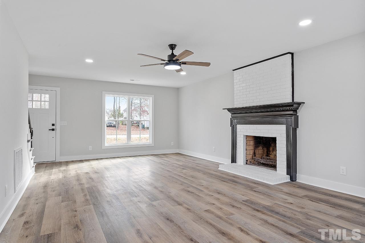 8205 Rocky Court Raleigh, NC 27616 - Photo 8 of 28 a view of empty room with wooden floor and fireplace
