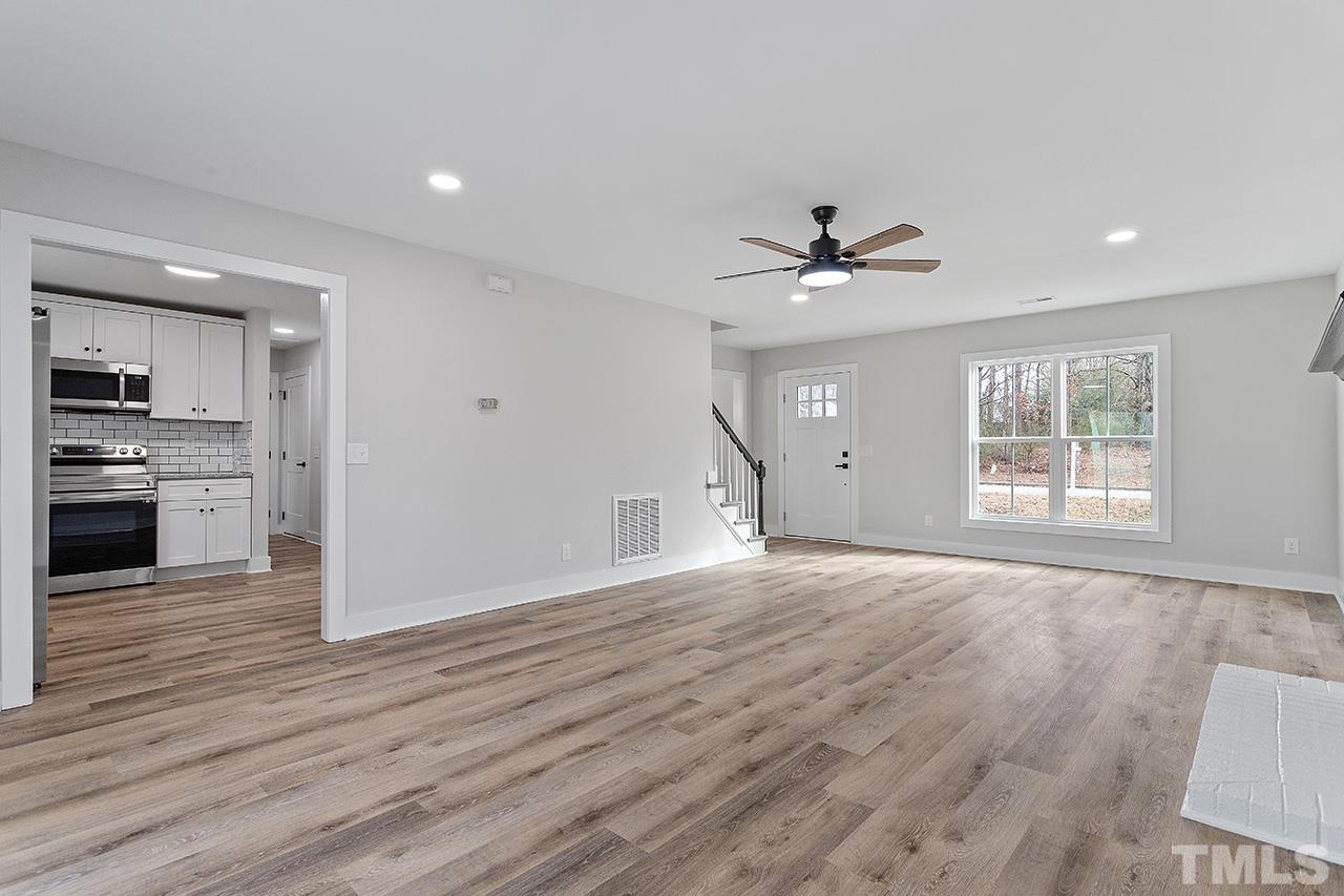 8205 Rocky Court Raleigh, NC 27616 - Photo 9 of 28 a view of an empty room with a window and wooden floor