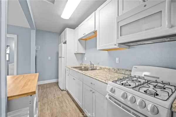 a kitchen with stainless steel appliances granite countertop a stove and a white cabinets