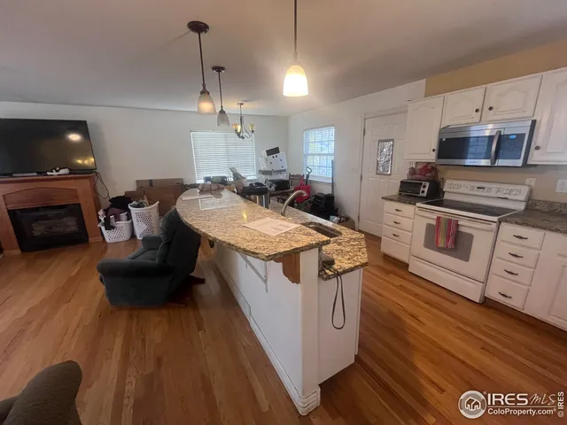 a kitchen with stainless steel appliances granite countertop a stove and a wooden floors