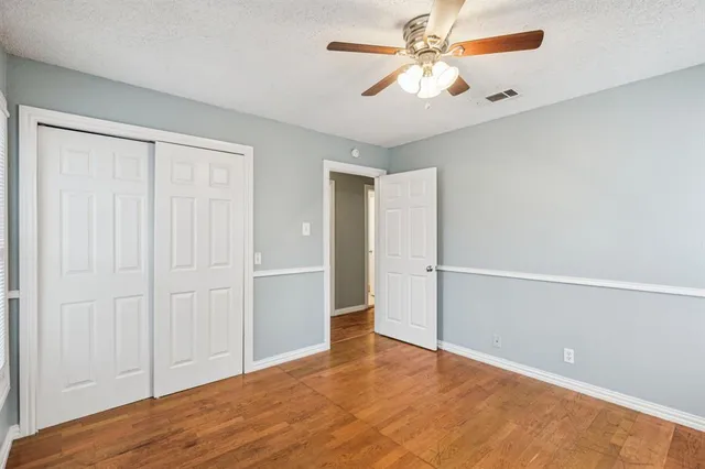 an empty room with closet and a chandelier fan
