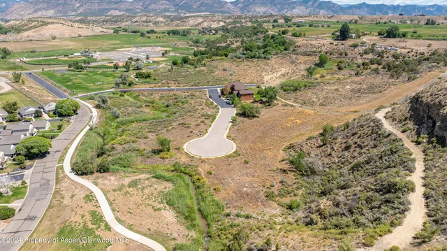 an aerial view of a house with a yard and lake view