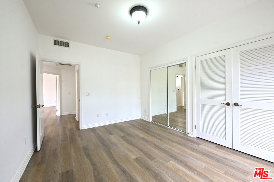 8555 Cashio Street, Unit PH4 Los Angeles, CA 90035 - Photo 13 of 43 a view of an empty room with wooden floor