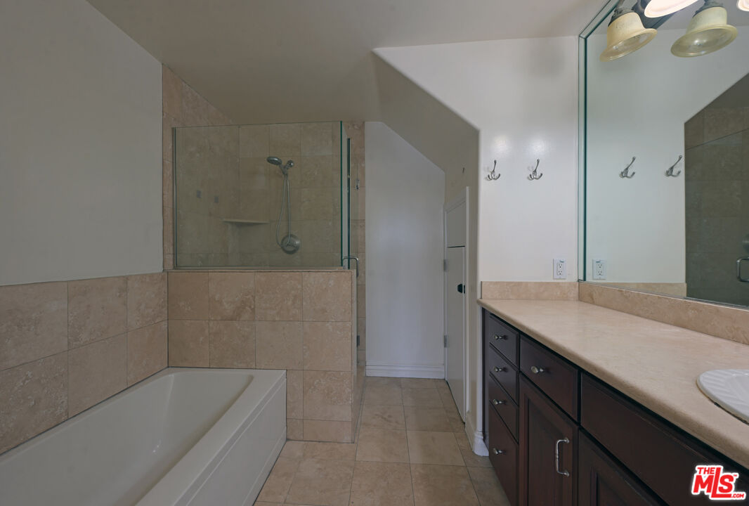 8555 Cashio Street, Unit PH4 Los Angeles, CA 90035 - Photo 19 of 43 a bathroom with a granite countertop sink a toilet a mirror and bathtub