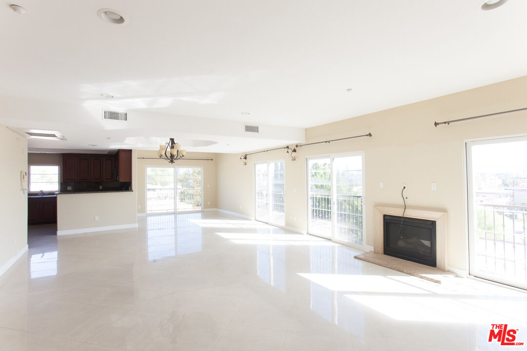 8555 Cashio Street, Unit PH4 Los Angeles, CA 90035 - Photo 2 of 43 a view of an empty room with a fireplace and a window
