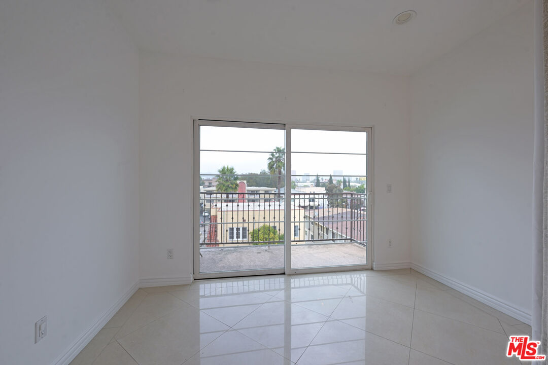 8555 Cashio Street, Unit PH4 Los Angeles, CA 90035 - Photo 24 of 43 an empty room with floor to ceiling window and an outdoor space