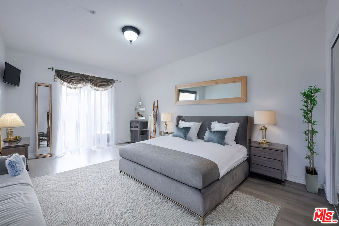 8555 Cashio Street, Unit PH4 Los Angeles, CA 90035 - Photo 35 of 43 a spacious bedroom with a bed and a potted plant