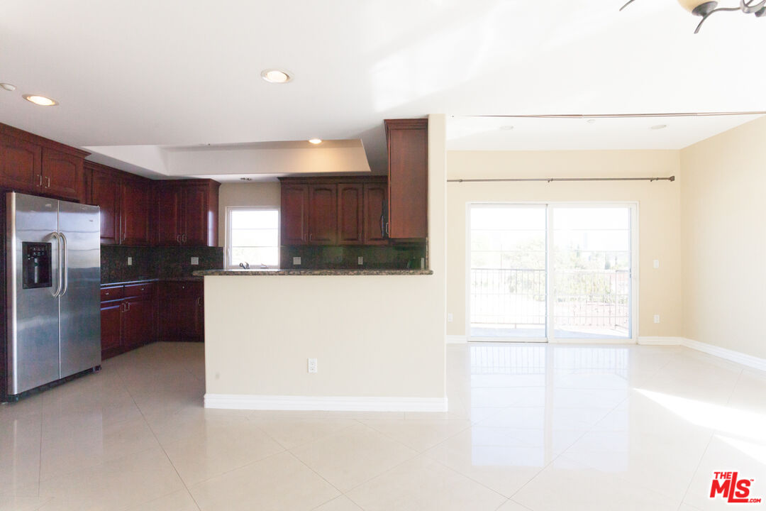8555 Cashio Street, Unit PH4 Los Angeles, CA 90035 - Photo 6 of 43 a large kitchen with a large counter top a refrigerator and a sink