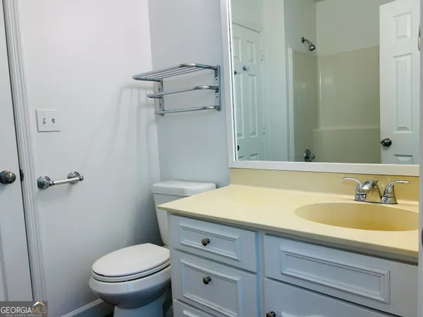 a bathroom with a granite countertop toilet a sink and a mirror