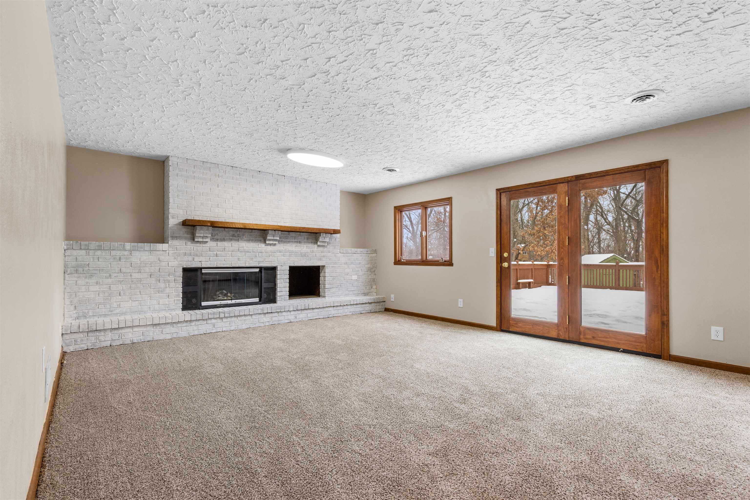 11738 Southgate Road Roscoe, IL 61073 - Photo 18 of 27 a view of an empty room with a fireplace and a window