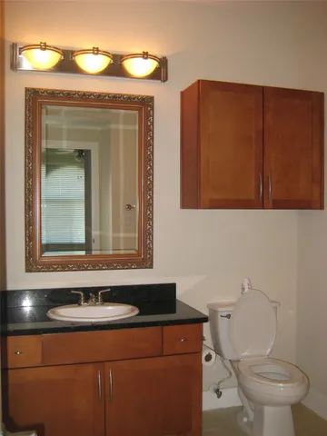 a bathroom with a toilet sink and mirror