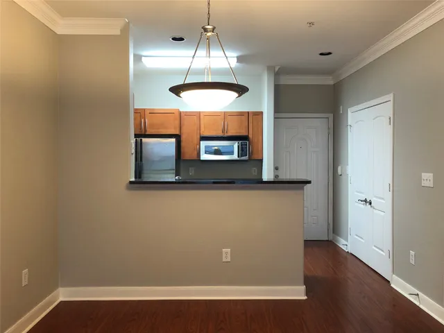 a view of a room with wooden floor and chandelier
