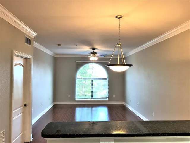 a room with a chandelier and wooden floor