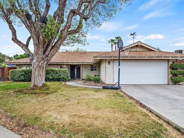 a view of a house with a tree in the yard