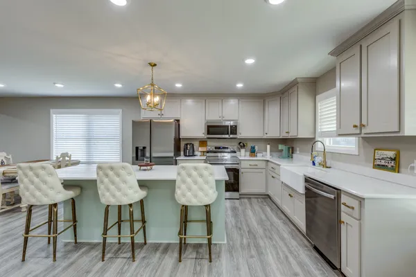a kitchen with stainless steel appliances granite countertop a sink dishwasher stove top oven and refrigerator