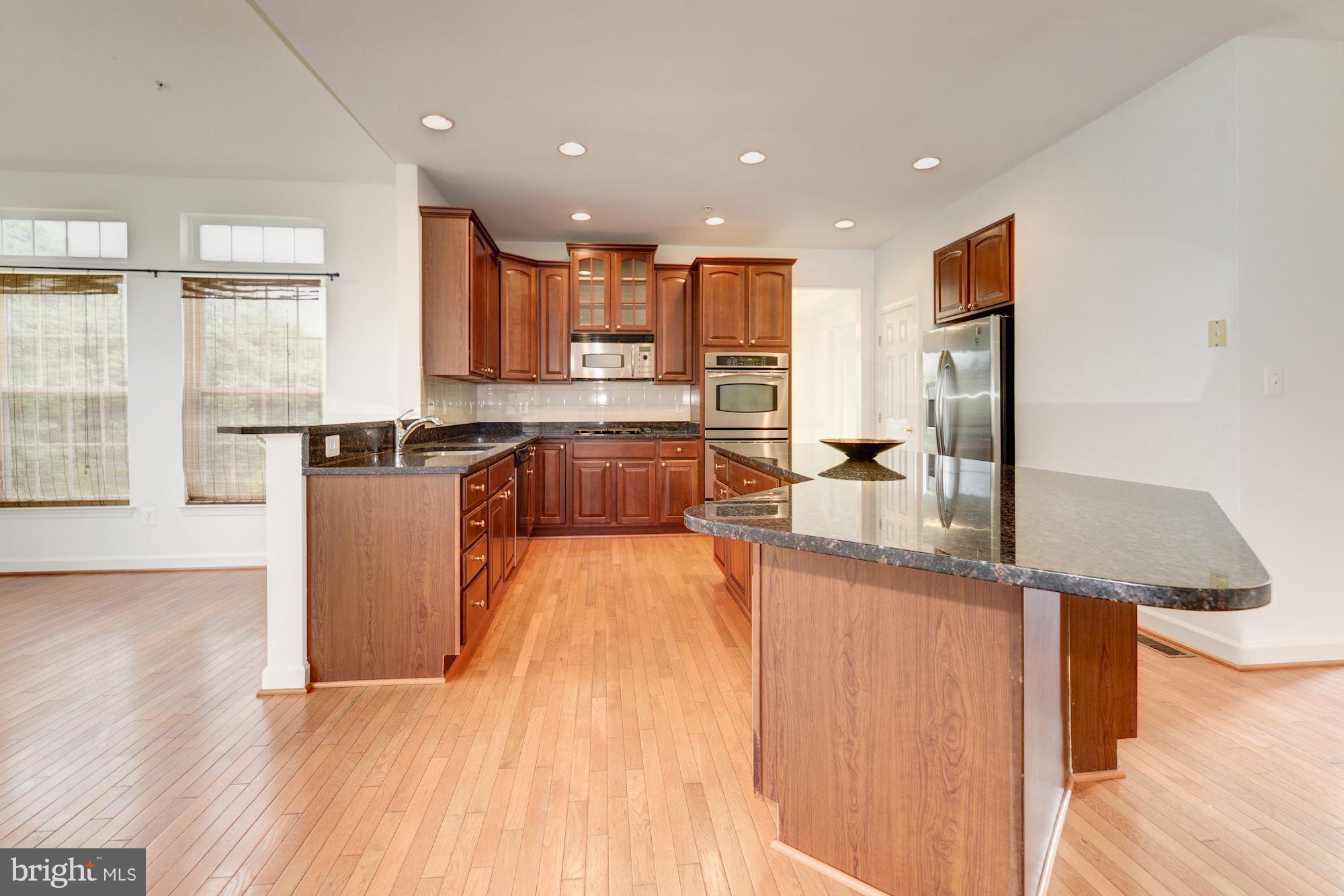 407 Potomac Ridge Drive Fort Washington, MD 20744 - Photo 5 of 30 a kitchen with stainless steel appliances granite countertop a sink a stove and a wooden floors