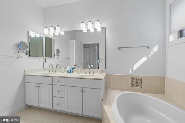 a bathroom with a sink double vanity granite tub and a mirror