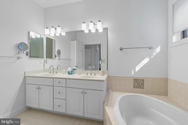 a bathroom with a sink double vanity granite tub and a mirror