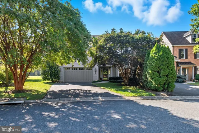 a view of a house with a yard and large trees