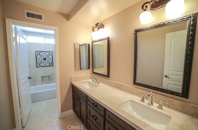 a bathroom with 2 sink tub and a mirror