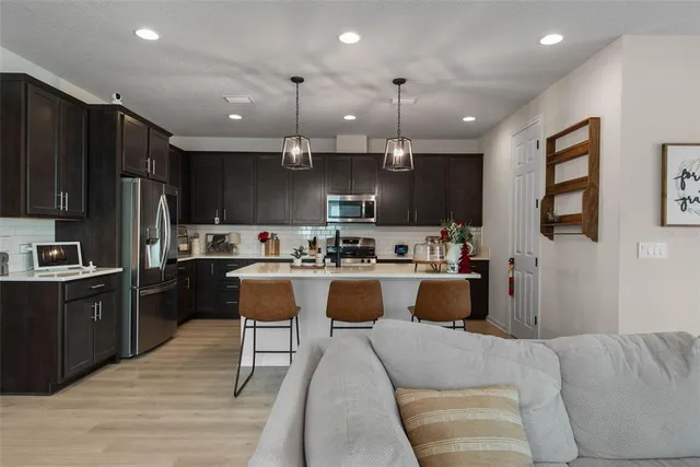 a kitchen with kitchen island stainless steel appliances lots of counter top space cabinets and a sink
