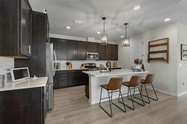 a kitchen with kitchen island granite countertop a sink counter top space appliances and cabinets