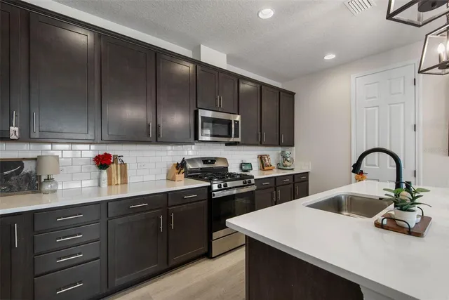 a kitchen with a sink a stove and cabinets