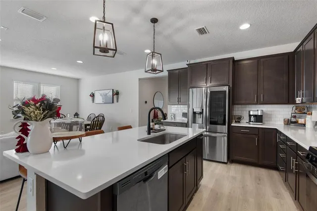 a kitchen with kitchen island a sink appliances and cabinets