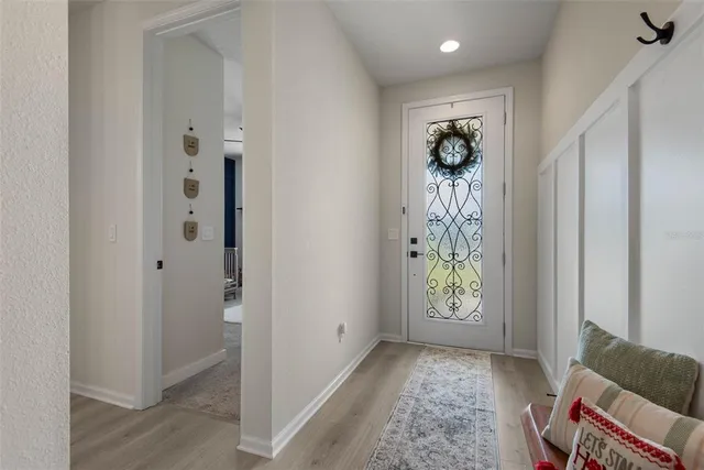 a view of hallway with window and wooden floor