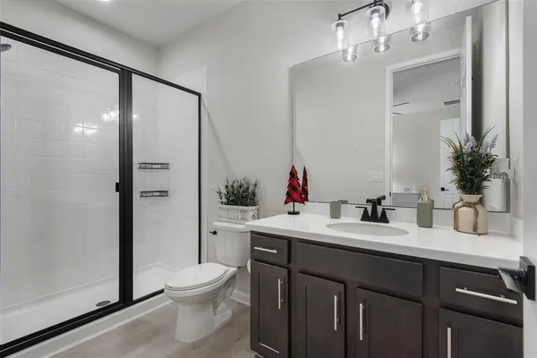 a bathroom with a granite countertop sink toilet a large mirror and shower