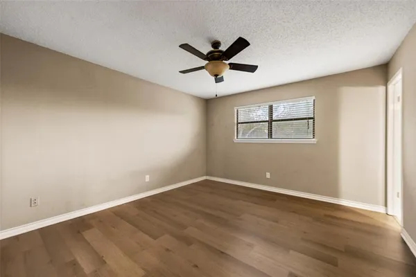 a view of a big room with wooden floor and windows