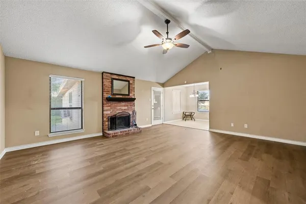 a view of an empty room with a fireplace and a window