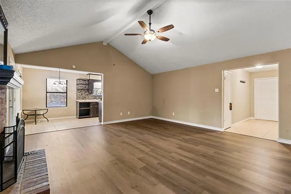an empty room with wooden floor and a ceiling fan