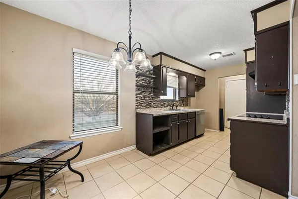 a kitchen with stainless steel appliances granite countertop a stove a sink dishwasher a refrigerator and a wooden cabinets